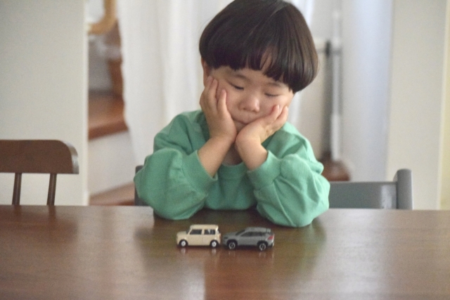 ミニカーで遊んでいる子供